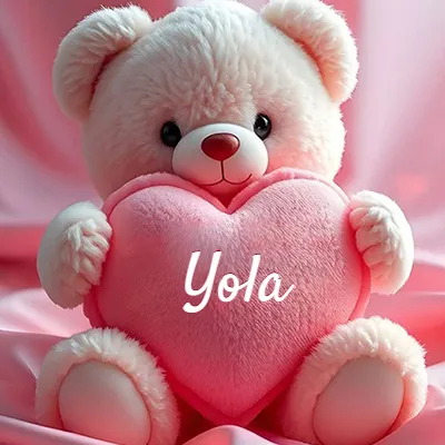 Osito de peluche polar de color crema, muy suave, sentado sobre pliegues de raso rosa brillante. Abraza un gran corazón de felpa rosa lleno de calidez. El nombre Yola aparece en letra cursiva en el centro del corazón rosa grande.